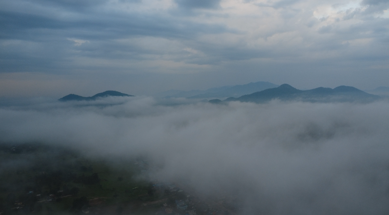 Misty mountains shrouded in low-hanging clouds at dawn.
