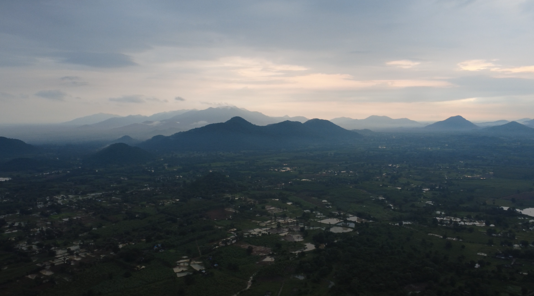 An aerial view of a rural area with rice paddies and scattered settlements.